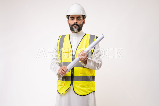 وظيفة ومهنة هندسية شبابية، بورتريه لمهندس عربي خليجي سعودي يرتدي الثوب التقليدي والسترة وخوذة الحماية يعمل في القطاع الهندسي في المملكة العربية السعودية، ادارة المشاريع الهندسية والانشاءات، مفهوم دراسة المخطط والمشروع البناء، خلفية بيضاء
