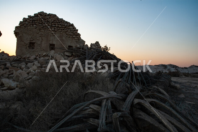 An abandoned old stone house, a historical archaeological site in the Kingdom of Saudi Arabia, a traditional heritage residential neighborhood, an old abandoned palm farm in one of the villages of Saudi Arabia