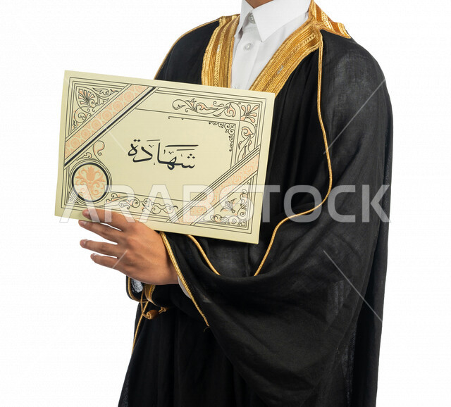 بورتريه لطالب جامعي عربي خليجي سعودي يرتدي العباءة وقبعة التخرج، يحمل بيده شهادة التخرج ، الاحتفال بانهاء الدرجة الجامعية ، حفل تخرج ، لباس التخرج ، خلفية بيضاء