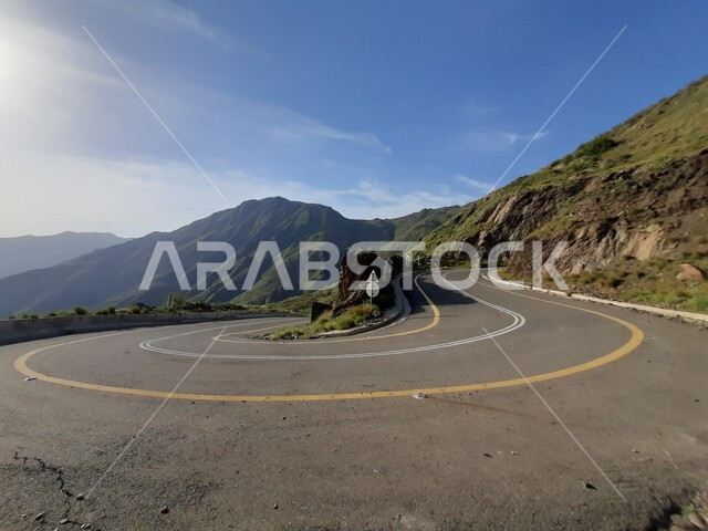 The nature and mountainous environment in Al Baha city, the peaks and heights in the Kingdom of Saudi Arabia, paved roads and expressways, interest in preparing the infrastructure, an asphalt road in the middle of the rocky mountains