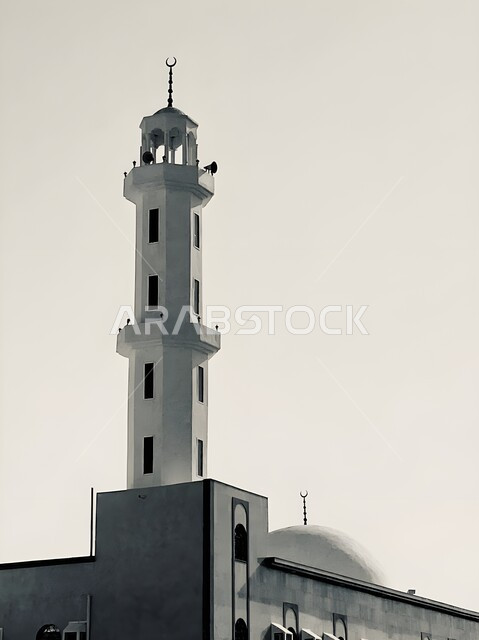 مفهوم العبادة والتقرب الى الله، صورة مقربة بالأبيض والأسود لمئذنة مسجد في مكة المكرمة، الفن الهندسي المعماري على الطراز الاسلامي لمنارات المساجد والجوامع، دعوة ونداء المسلمين الى الصلاة في المملكة العربية السعودية