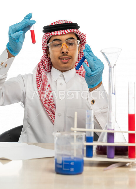 بورتريه لطالب جامعي عربي خليجي سعودي يرتدي الزي الخليجي التقليدي ،يجلس في معمل الكيمياء ، استخدام انابيب الاختبار لاجراء التجارب في المختبر ، التفاعلات الكيميائية ،البحث والتطوير ، مفهوم الكيمياء الحيوية