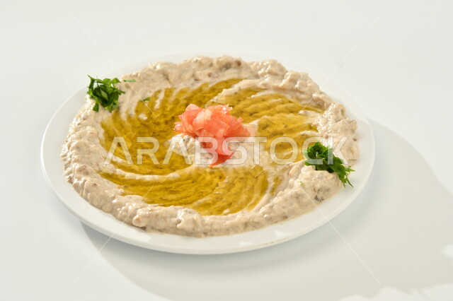 المقبلات العربية الباردة، طبق من متبل الباذنجان اللذيذ المزين بالرمان والبقدونس، مطاعم للمأكولات العربية الشرقية، وجبات الطعام الشهية، اكل عربي شرقي, خلفية بيضاء