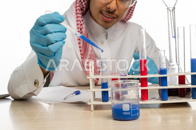 بورتريه لطالب جامعي عربي خليجي سعودي يرتدي الزي الخليجي التقليدي ،يجلس في معمل الكيمياء ، استخدام انابيب الاختبار لاجراء التجارب في المختبر ، التفاعلات الكيميائية ،البحث والتطوير ، مفهوم الكيمياء الحيوية