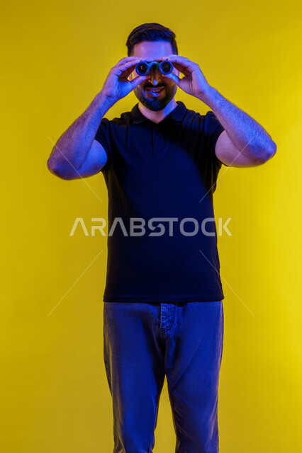 Using a telescope to see distant objects, a Saudi man looking through binoculars, a portrait of a young Emirati Gulf Arab man wearing casual clothes, yellow background, using binoculars and the love of exploration and adventure, planning for future goals and ambitions