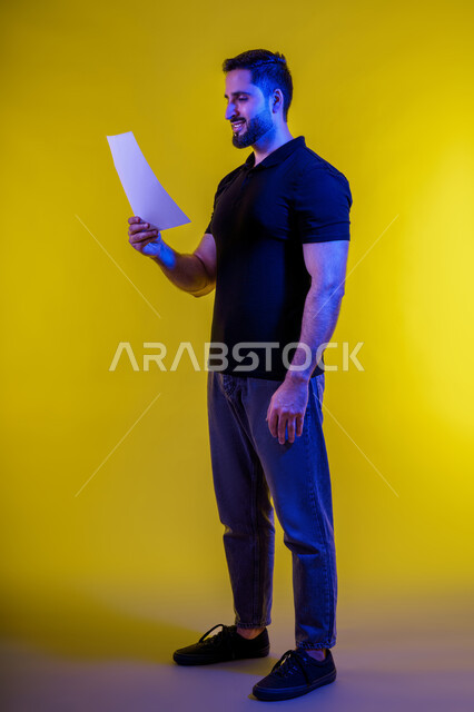 التفكير بالمستقبل، التأمل والتخطيط، رجل عربي خليجي سعودي يرتدي الزي االكاجوال يحمل بيده كراسه تدوين الملاحظات، افكار وحلول، التفكير بالمستقبل، بورتريه لشاب اماراتي تبدوعليه ايماءات التمعن والتركيز، خلفيه صفراء