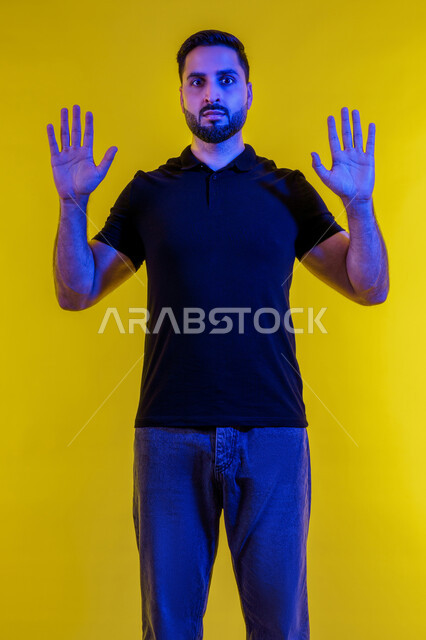 الرهبه من شيء ما، رجل إماراتي يشعر بالدهشة والصدمة والدهشة، صورة لشاب خليجي سعودي يرتدي ملابس غير رسمية ينظر إلى الكاميرا بحركات من الخوف والذعر، خلفية صفراء