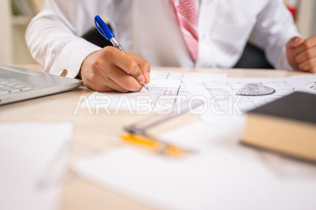 A Saudi Arabian Gulf university student studying architecture, studying university lectures, a diligent student studying in the university library, studying for exams, completing architectural project plans, a new engineering architectural project, an arc