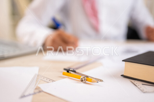 طالب جامعي عربي خليجي سعودي يدرس الهندسة المعمارية, مذاكرة المحاضرات الجامعيه, تلميذ مجتهد يدرس في مكتبة الجامعة, المذاكره للإختبارات, انجاز مخططات المشاريع المعمارية, مشروع معماري هندسي جديد, مخطط معماري قيد الانشاء