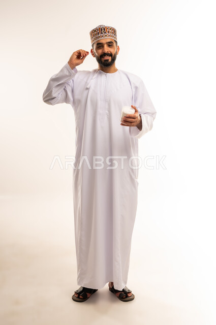 Caring about elegance and outward appearance, maintaining a white smile, the concept of oral health care, ensuring dental hygiene after eating, a portrait of an Arab Gulf Omani man wearing a dishdasha and a kuma, cleaning his teeth using dental floss, a full body image, a white background.