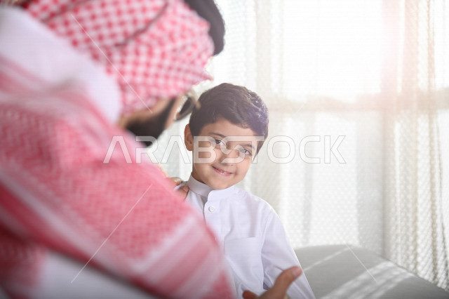A Saudi Arabian Gulf man talking to his son, guidance and advice, telling a useful story, caring for and taking care of children, communication between parents and children