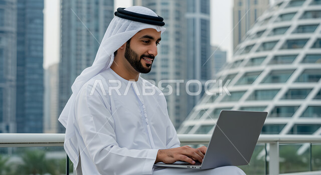 Working in UAE companies, performing tasks and office work outdoors, side view of an Emirati Gulf Arab man wearing a kandura and ghutra sitting outside working on a laptop, integrating technology into work life