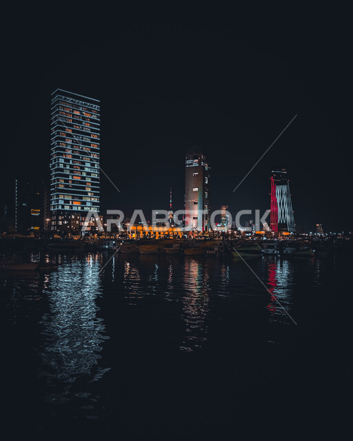 الفن الهندسي للابراج وناطحات السحاب المضيئة في المساء، التصاميم الهندسية المعمارية على الطراز الحديث والمتطور، التقدم العمراني للمنشأت في الكويت على ساحل الخليج العربي، الواجهه البحرية في مدينة الكويت، مناطق جذب واستقطاب السياح من جميع انحاء العالم