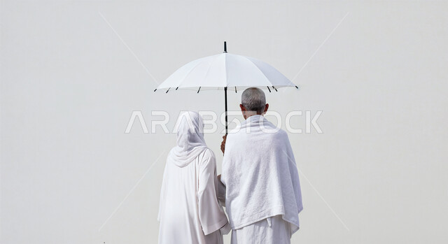 التظلل من اشعة الشمس باستخدام المظلة، مفهوم أركان الإسلام وأداء الفرائض الدينية، بورتريه مقرب من الخلف لحاج كبير بالسن خليجي عربي سعودي يرتدي ثياب الإحرام يقف بجانب زوجته باستقامة، تأدية مناسك الحج والعمرة، العبادة والتقرب إلى الله، خلفية بيضاء