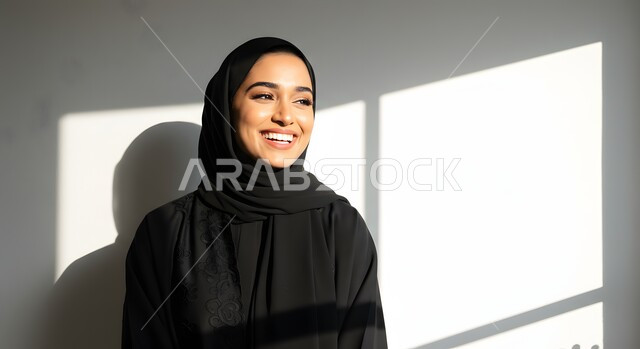 الاهتمام بالمظهر الخارجي، مفهوم الأنوثة والنعومة، الملامح العربية القوية، أزياء محجبات عصرية وأنيقة، صورة مقربة لشابة عربية خليجية سعودية ترتدي العباءة والحجاب بإيماءات البهجة والسرور