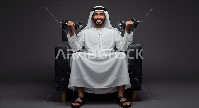 Physical activity to maintain physical fitness, portrait of an Emirati Gulf Arab man wearing a kandura and ghutra exercising with dumbbells, bodybuilding and muscle building, weightlifting exercises (dumbbells), heavy iron weights, gray background