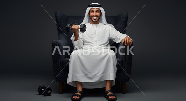 نشاط بدني للمحافظة على اللياقة الجسدية، بورتريه لرجل عربي خليجي اماراتي يرتدي الكندورة والغترة يمارس التمارين الرياضية مع الدمبل، كمال الأجسام و بناء العضلات، تمارين رفع الأثقال (دمبلز)، الأوزان الحديدية الثقيلة، خلفية رمادية