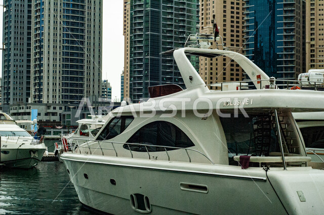Towers and skyscrapers in the United Arab Emirates, the advanced architecture of commercial facilities, a famous coastal landmark and tourist spot, a yacht port and marine transportation during the day