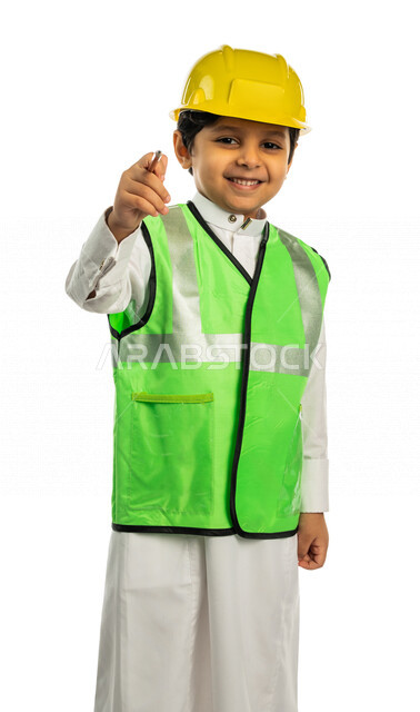 Portrait of a Saudi Arabian Gulf boy wearing a protective helmet and a work protective jacket, holding a pen in his hand to write, pointing with the pen to write on the air, future profession, white background, the concept of engineering, engineering prof