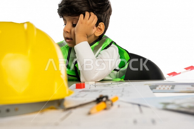 بورتريه لفتى عربي خليجي سعودي داخل مكتب هندسي يده على خده بإيماءات وجه ويدين مختلفة ، خوذة الوقاية ، أدوات ومعدات هندسية ، يرتدي سترة الحماية الخاصة بالعمل ، مهنة مستقبلية ، خلفية بيضاء ، مفهوم الهندسة المعمارية ، مهن ووظائف هندسية