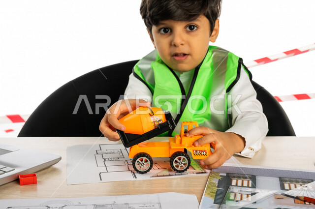 Portrait of a Saudi Arabian Gulf boy in an engineering office, in his hand, a small cement mixer truck toy, using a laptop computer, engineering tools and equipment, wearing a work protection jacket, engineering plans and designs, futuristic profession, w