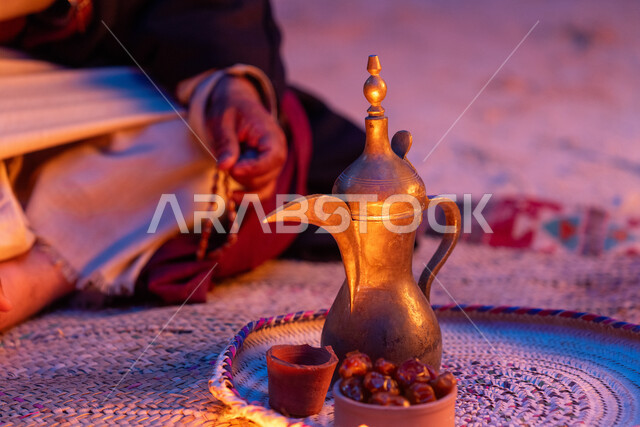  ذكرى تأسيس الدولة السعودية الاولى 22 فبراير، يوم بدينا 1727 م، الاحتفال بالمناسبات والأعياد الوطنية، صورة مقربة لرجل عربي خليجي سعودي يرتدي الأزياء التراثية يجلس بجانب دلة القهوة النحاسية، عادات وتقاليد موروثة، مفهوم الكرم وحسن الاستقبال