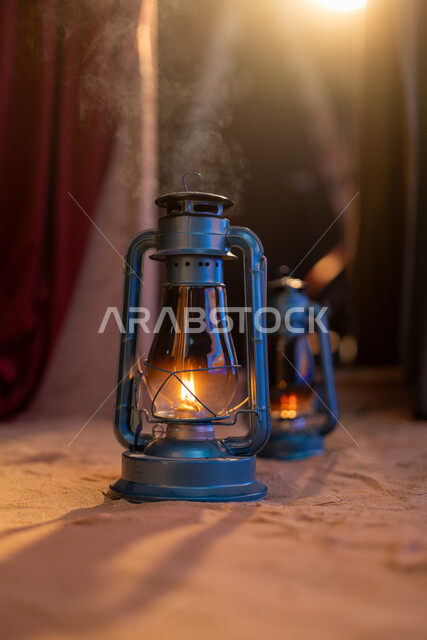  مصباح قديم الطراز مصنوع من النحاس، قنديل شعبي على  الارض في احدى قرى المملكة العربية السعودية، تحفة تقليدية شعبية, فانوس أثري معدني قديم