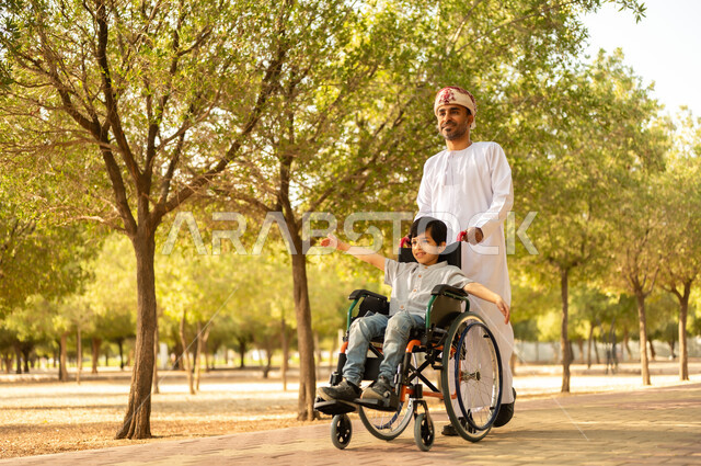 شعور ذوي الهمم بالراحه والطمأنينه في بيئتهم, عائلة عربيه خليجيه عمانية برفقه ابنها في إحدى الحدائق للاستمتاع بالهواء الطلق، ولد عماني مقعد يجلس على كرسي متحرك في أحد المنتزهات، منح مرضى ذوي الإعاقة الحركية طاقة ايجابية