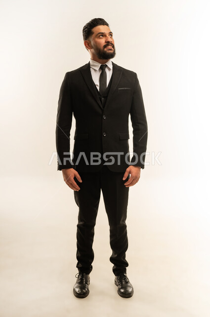 الوقوف باستقامة بايماءات الثقة بالنفس, التقاط صورة شخصية للوثائق الرسمية، مفهوم الاناقة والرجولة, بورتريه لرجل أعمال أجنبي يرتدي البدلة الرسمية ينظر الى شيء ما بتعابير السرور والسعادة, الاهتمام بالمظهر الخارجي، الطول الكامل للجسم، خلفية بيضاء