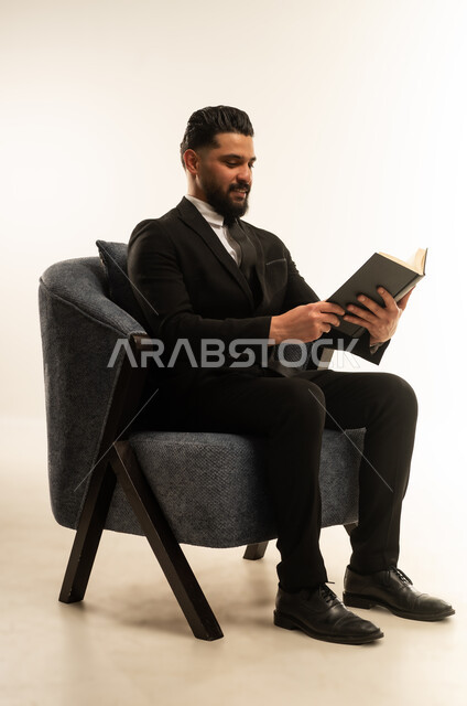 اعداد التقارير الخاصة بالعمل، تعابير السرور والتركيز، التدقيق في قراءة الملاحظات، بورتريه لرجل اعمال اجنبي يرتدي البدلة الرسمية يحمل بيده دفتر العمل، مراجعة ومتابعة الخطط والمشاريع  بإيماءات السعادة والسرور، خلفية بيضاء