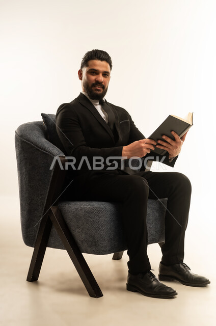 اعداد التقارير الخاصة بالعمل، تعابير السرور والتركيز، التدقيق في قراءة الملاحظات، بورتريه لرجل اعمال اجنبي يرتدي البدلة الرسمية يحمل بيده دفتر العمل، مراجعة ومتابعة الخطط والمشاريع  بإيماءات السعادة والسرور، خلفية بيضاء