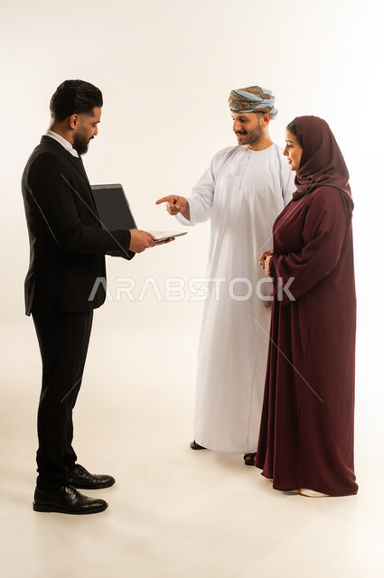 استخدام الحاسب المحمول، تبادل الخبرات بين البلاد، بورتريه لفريق عمل عربي خليجي عماني في اجتماع مع رجل اجنبي يرتدي البدلة الرسمية بتعابير السرور والسعادة، استضافة رجال الاعمال الاجانب في سلطنة عمان، الجسم بالطول الكامل، خلفية بيضاء