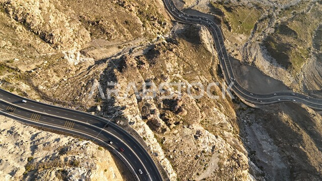 طريق إسفلتي ملتوي وعر وسط الجبال الصخرية، الطبيعة والبيئة الجبلية القاسية في مدينة الطائف، القمم والمرتفعات في المملكة العربية السعودية، حركة مرور السيارات في طريق عقبة الهدا، الطرق والشوارع المعبدة السريعة بين مكة والطايف, الاهتمام بتهيئة البنية التحتية