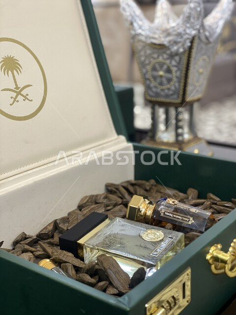 A local Saudi product, the authenticity of customs and traditions in the Kingdom of Saudi Arabia, perfuming and scenting with the finest scents and perfumes, a box filled with luxurious oud wood and charcoal with the logo of the two swords and the palm tree, a traditional decorated incense burner