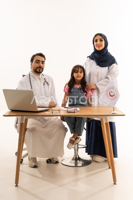 المساهمة في الخدمات الطبية الإسعافية الطارئة، دمج التكنولوجيا والتقنية في المجال الطبي والصحي، العمل في هيئة الهلال الأحمر السعودي، بورتريه لطبيبين سعوديين عربيين خليجيين يرتديان المعطف الأبيض يقومان فتاة، العمل على الحاسوب المحمول، خلفية بيضاء