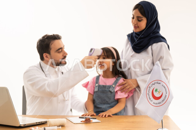 الإسهام في الخدمات الطبية الإسعافية الطارئة، دمج التكنولوجيا والتقنية في المجال الطبي والصحي، العمل في هيئة الهلال الأحمر السعودي، بورتريه لطبيبين سعوديين عربيين خليجيين يرتديان المعطف الأبيض يقومان بفحص حرارة فتاة، العمل على الحاسوب المحمول، خلفية بيضاء