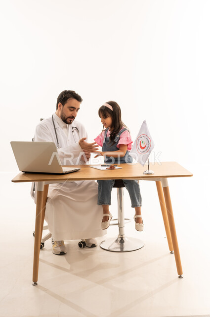 توفير الخدمة الطبية الإسعافية الطارئة بالمملكة، دمج التكنولوجيا والتقنية في المجال الطبي والصحي، العمل في هيئة الهلال الأحمر السعودي، بورتريه لطبيب سعودي عربي خليجي يرتدي المعطف الأبيض بملاطفة فتاة يعمل على الحاسوب المحمول، خلفية بيضاء
