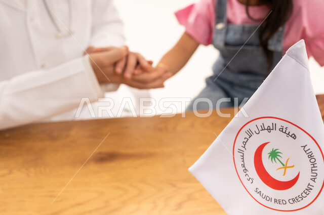 العمل في المجال الطبي والصحي، هيئة الهلال الأحمر السعودي، بورتريه لطبيب سعودي عربي خليجي يرتدي المعطف الأبيض يقوم بمصافحة فتاة صغيرة، الإسهام في الخدمات الإنسانية والاجتماعية، تقديم الخدمة الطبية الإسعافية الطارئة بالمملكة، خلفية بيضاء