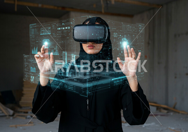 خلفية هولوجرامية ثلاثية الأبعاد لمخططات هندسية معمارية، استعمال التقنيات الحديثة لمتابعة المشاريع والتصميمات الإنشائية المتطورة، شابة عربية خليجية سعودية  محجبة ترتدي العباءة وتضع نظارات في آر وتقوم بمتابعة المشروع البنائي، رؤية مستقبلية سعودية 2030