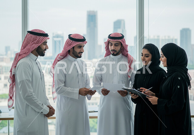 روح الفريق والعمل الجماعي، موظفون عرب خليجيون سعوديون يتناقشون ويعقدون الاتفاق داخل المكتب في مقر الشركة, وضع الاستراتيجيات والخطط لتحقيق أهداف الشركة، ضمان فهم واضح وشامل للأعمال