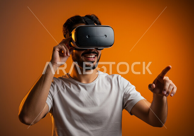 التكنولوجيا الحديثة واستخدام الأجهزة المتطورة، المتعة والتسلية بمحاكاة العالم الخيالي، الاندماج والتفاعل مع الواقع الافتراضي, بورتريه مقرب لرجل عربي خليجي سعودي يرتدي الزي الكاجوال ونظارة في آر ثلاثية الأبعاد بايماءات التفاعل, خلفية برتقالية