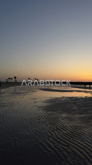 The beach coasts and waterfront in Sharjah, a destination for tourists from all over the world, famous coastal tourist attractions and places in the United Arab Emirates, enjoying the calm sea waves at sunset