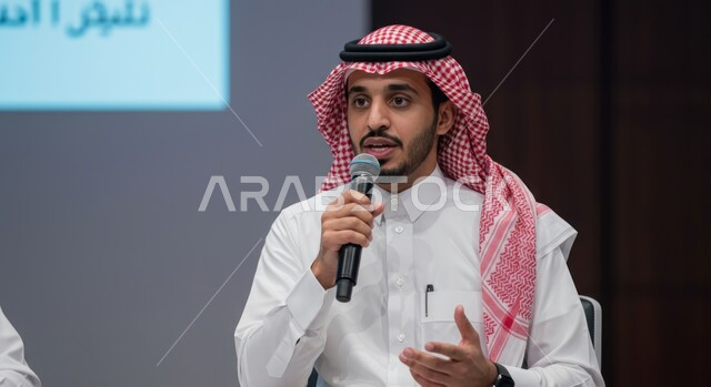 المشاركة بالمؤتمرات الثقافية، اتقان فن الالقاء والخطابة، مهارات التحدث والحوار، شاب عربي خليجي سعودي يرتدي الثوب التقليدي والشماغ يقوم بتقديم ورش العمل والدورات التدريبية باستخدام مكبر الصوت، ايماءات وتعابير الاندماج والتركيز والثقة بالنفس