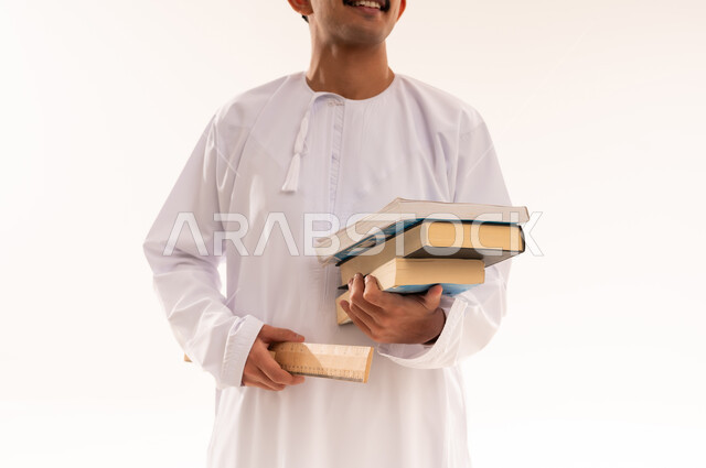 التعليم في المملكة العربية السعودية، مهن ووظائف هندسية، إيماءات وجه تدل على الفرح والنجاح ، بورتريه  مقرب لطالب جامعي يرتدي الزي الخليجي السعودي و الخوذة يحمل بيده كتب ومعدات الهندسة يقوم بالنظر الي شيء ما، إدارة المشاريع الهندسية ،الجسم بالطول الكامل، خلفية بيضاء