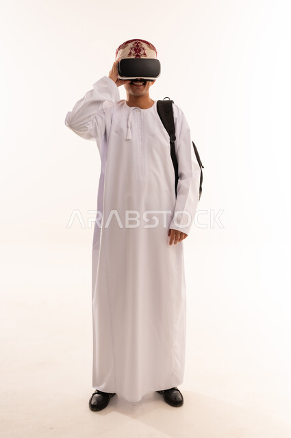 Integration and interaction with the imaginary world, use of advanced techniques and technology, portrait of a young Arab Gulf Omani man wearing a dishdasha and an Omani kummah, wearing VR glasses, watching virtual reality movies, having fun, full body, white background
