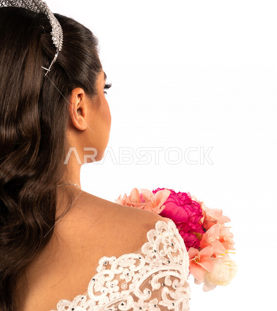 بورتريه بزاويه من الخلف لعروسة عربية خليجية سعودية جميلة تقوم بجلسة تصوير بإيماءات وجه ويدين مختلفة ، أجمل اطلالة لعروسة سعودية عربية خليجية في يوم زفافها ، ترتدي بدلة الزفاف البيضاء ، تحمل بيدها باقة ورد جميلة ، ليلة العمر ، مناسبات وأفراح