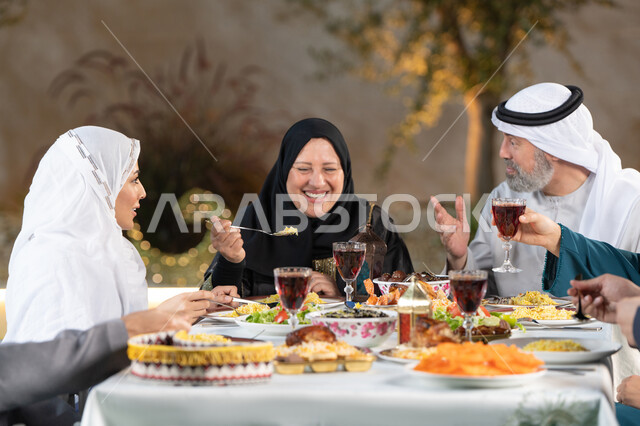 حسن الضيافه والإستقبال، مائدة طعام مليئة بأصناف من المأكولات والمقبلات الشهية، الأجواء الرمضانية العائلية السعيدة، الاحتفال بقدوم شهر رمضان المبارك، عائله عربية خليجيه اماراتية  تقوم بتناول الطعام، اسلاميات وعبادات رمضانية