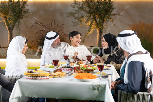 مائدة طعام مليئة بالوجبات الرمضانية المتنوعة، نقاشات وحوارات عائلية، أجواء أسرية مليئة بالحب، اجتماع الاسرة حول مائدة الطعام، عائلة عربية خليجيه إماراتيه تستعد لتناول الفطار، العزائم والولائم في الأعياد والمناسبات الإسلامية