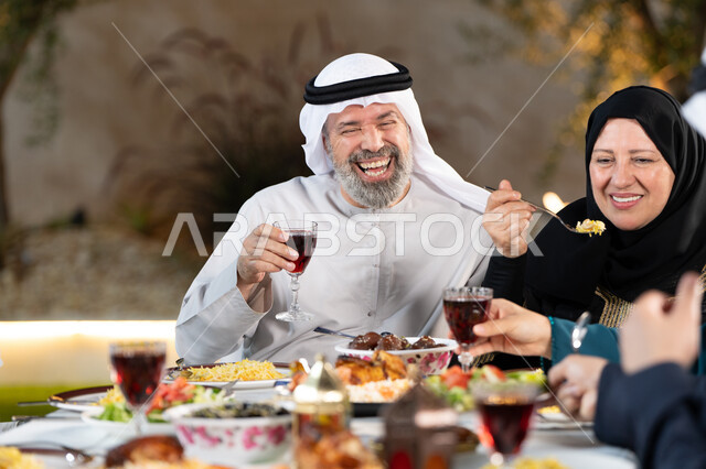 Enjoying fresh drinks, Ramadan breakfast and Friday gatherings with family and friends for breakfast, an Arab Gulf Emirati family gathered around a dining table filled with delicious foods, Islamic occasions and holidays, the joy of family gatherings