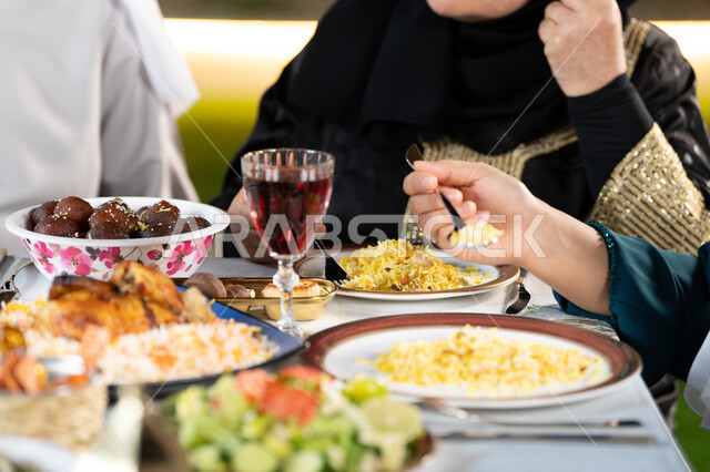 سفرة مليئة بأصناف المأكولات والمقبلات الشهية، الوجبات والأطباق الرئيسية على مائدة الطعام،  صورة مقربة ليد امراة عربيه خليجيه اماراتية تقوم بتناول الارزالشهي، اجتماع الأسرة حول مائدة الطعام، أداء فريضة الصيام